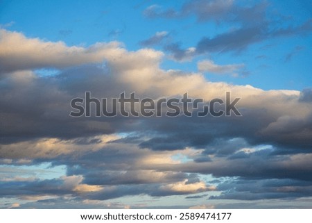 Dark storm clouds clash with the warm sunset glow, forming a striking and moody evening sky.