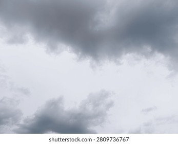 Dark storm clouds moving across a grey sky, creating a gloomy and overcast natural atmosphere indicating impending weather changes and a sense of drama