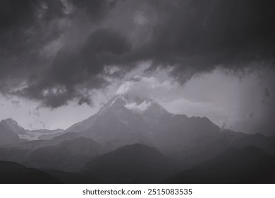 Dark storm clouds over mountain peak
A towering mountain peak shrouded in mist, with dark, stormy clouds looming overhead, creating a dramatic and moody landscape.
 - Powered by Shutterstock