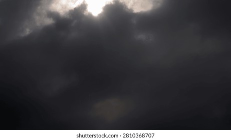 Dark storm clouds with sun rays piercing through sky