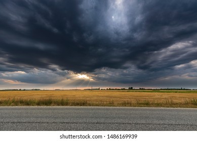 Dark Storm Sky And Open Field During Sunset.