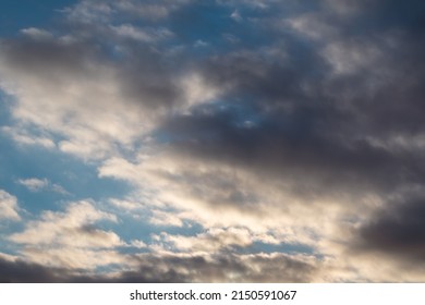 Dark stormy high clouds on blue sky with sunset shine, cloudscape background. Skyscape natural heavenly scenery