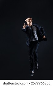 In a dark studio, a man in a sharp navy suit leaps mid-air, reaching upwards with determination. dynamic pose highlight ambition and success.