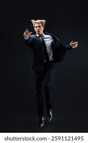 In a dark studio, a man in a sharp navy suit leaps mid-air, reaching upwards with determination. dynamic pose highlight ambition and success.