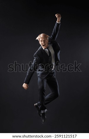 In a dark studio, a man in a sharp navy suit leaps mid-air, reaching upwards with determination. dynamic pose highlight ambition and success.