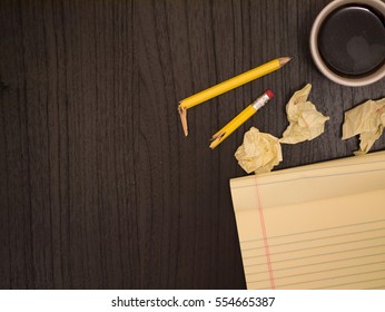 Dark surface, yellow, crumpled paper broken pencil, coffee, frustration - Powered by Shutterstock