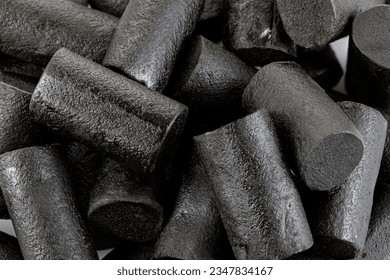 Dark sweet and salt licorice candies. Black licorice chunks isolated on white background. Close up