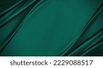 Dark teal emerald green silk satin. Shiny smooth fabric. Soft folds. Luxury background with space for design. web banner. Flat lay, top view table. Birthday, Christmas, Valentine, New year.