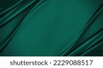 Dark teal green silk satin. Shiny smooth fabric. Soft folds. Luxury background with space for design. web banner. Flat lay, top view table. Birthday, Christmas, Valentine, New year.