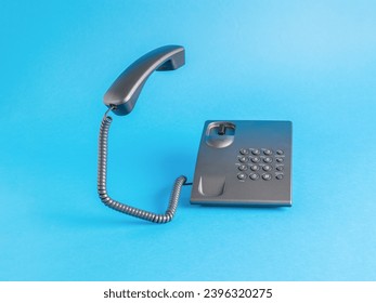A dark telephone on a light blue background. Classic retro telephone connection. - Shutterstock ID 2396320275