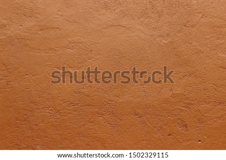 Dark terracotta plaster rough wall texture background
