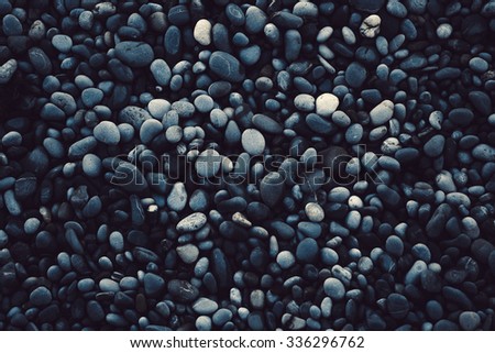 Dark texture pebble closeup. Pebbles on the shore.
