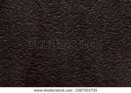 Dark textured background image resembling divoted or dimbled brown stone.