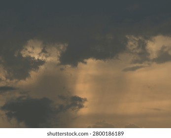 Dark thick clouds that partially obscure the bright sun twilight rays sunlight penetrating through clouds stormy weather or afternoon skies.
