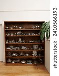 Dark timber cabinet displaying silverware in thrift store