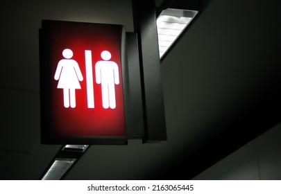 Dark Tone Public Restrooms Backlit Sign With Blurred Background.