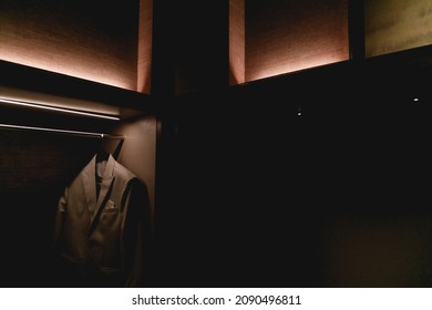 Dark Tone Room With A Suit Hanging In The Closet.