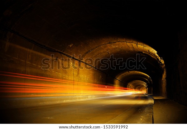 Dark tunnel with moving lights. Old tunnel with lines of\
bright light. 
