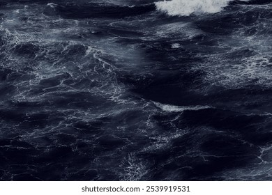 Dark, turbulent ocean waves crash and swirl, creating a dynamic, moody scene. - Powered by Shutterstock