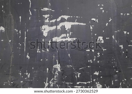 Dark, weathered wall surface featuring chipped white paint spots and random scratches, creating a rugged urban background. Ideal for design projects needing texture, grunge, or distressed look.