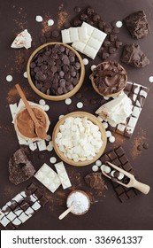 Dark And White Chocolate Chips, Bar, Sugar Powder, Cacao And Chocolat Butter On Brown Background