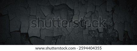 Dark wide panoramic background. Peeling paint on a concrete wall. Dark grunge texture of old cracked flaking paint. Weathered rough painted surface. Patterns of cracks. Darkness background for design.