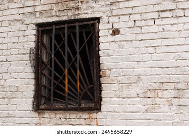 A dark window with an old rusty grate in an abandoned house - Powered by Shutterstock