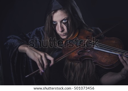 Dark woman violinist, horror girl playing scary lullaby on her violin, halloween concept