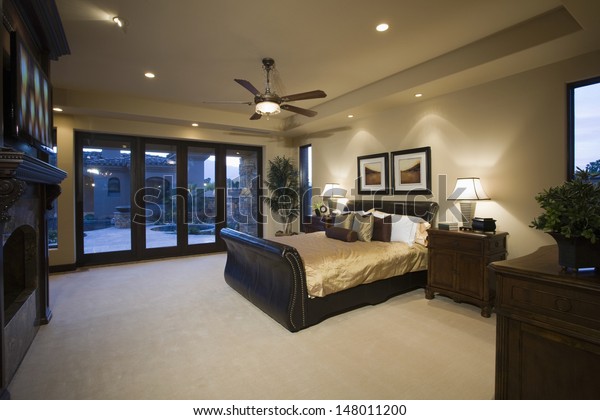 Dark wood\
furniture in bedroom with ceiling\
fan