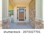 Dark wooden front door with transom window and side panels