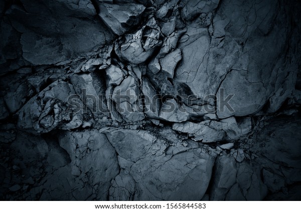 Darkened background of a\
black rock wall