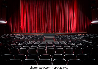 Darkened empty movie theatre and stage with the red curtains drawn viewed over rows of vacant seats from the rear - Shutterstock ID 1804295407