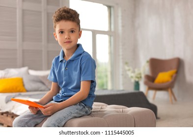 Dark-eyed Boy. Dark-eyed Pleasant Looking Cute Boy Wearing Jeans Feeling Amazing While Playing With Toys