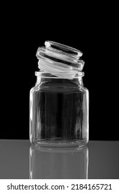 Dark-field Lit Glass Apothecary Jar With Lid Ajar And Reflective Surface Image. Copy-space