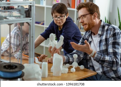 Dark-haired Friends. Smart Informative Bearded Teacher Carrying Model Of Skull And Explain Principles Of It Creation