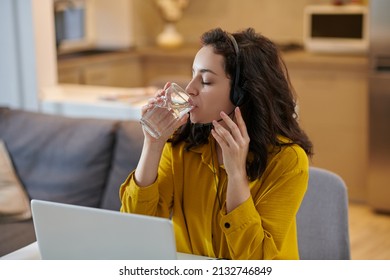 Dark-haired Woman In A Mustard Shirt Drinking Water