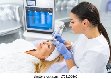 Dark-haired Young Caucasian Professional Dermatologist Doing A Cosmetic Procedure For Improving Her Clients Skin Elasticity