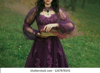 a dark-haired young lady holds in her hands an open Pandora's box, the red maroon thick fog of evil and disease slowly comes out, as a punishment for humanity. gothic image, art photo without a face