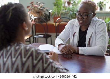 Dark-skinned Girl, Doctor, Takes A Latino Patient. Doctor And Patient Of Mixed Race.