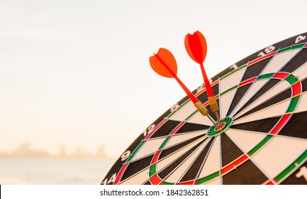 Dart arrow hitting to center on bullseye (bull's-eye) dartboard is the target of purpose challenge business at sunset, expert marketing strategy target, objective financial and goal success - Shutterstock ID 1842362851