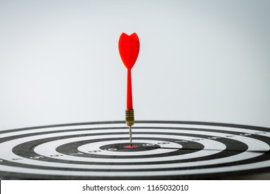 dart arrow hitting in the target center of dartboard. concept of the success - Shutterstock ID 1165032010