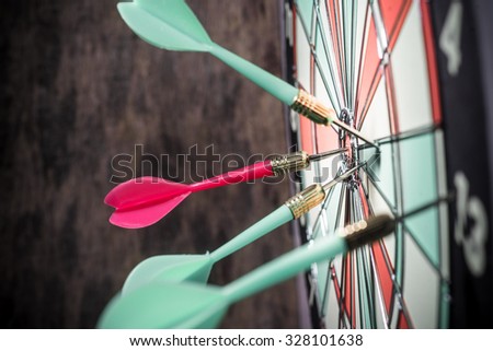 Dart in bulls eye of dartboard concept for hitting target dart success concept