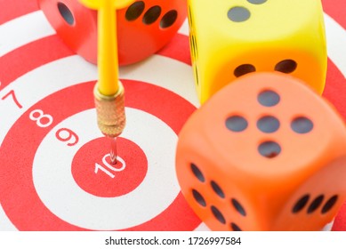 Dart hits in the center number 10 of a target or bullseye with dices, depicting role of probability concepts in business decision making used for estimating future returns and profitability of a firm - Shutterstock ID 1726997584