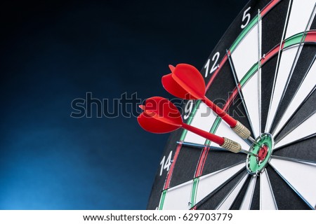Dartboard on a blue background with arrows hitting the center target