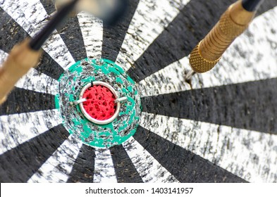 Darts Missing Bullseye on a Worn Out Dartboard. Proper Targeting, Losing Concept.