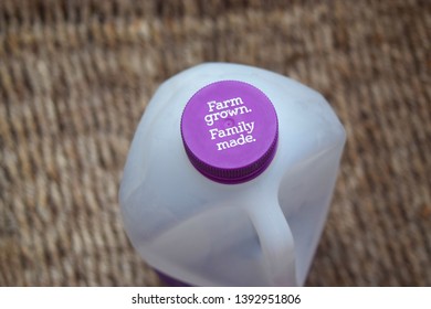 Darwin Australia December 2018: Milk Container With Purple Cap With Words On It Farm Grown Family Made On Dark Background.