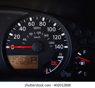 Dashboard Of A Car Showing Tachometer, Partial Speedometer, Temperature Gauge, Battery Guage, Seat Belt Warning Light And Open Door Warning Light