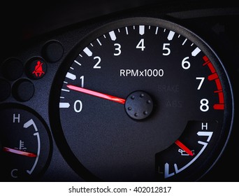 Dashboard Of A Car Showing Tachometer, Partial Speedometer, Temperature Gauge, Battery Guage, Seat Belt Warning Light And Open Door Warning Light