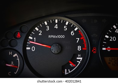 Dashboard Of A Car Showing Tachometer, Partial Speedometer, Temperature Gauge, Battery Guage, Seat Belt Warning Light And Open Door Warning Light