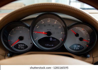 Dashboard Is Covered In Beige Genuine Leather Of A Sports Car Brand Porsche With Instruments Speedometer And Tachometer Displays Are Highlighted On A Black Background With A Red Dial And And An Arrow.